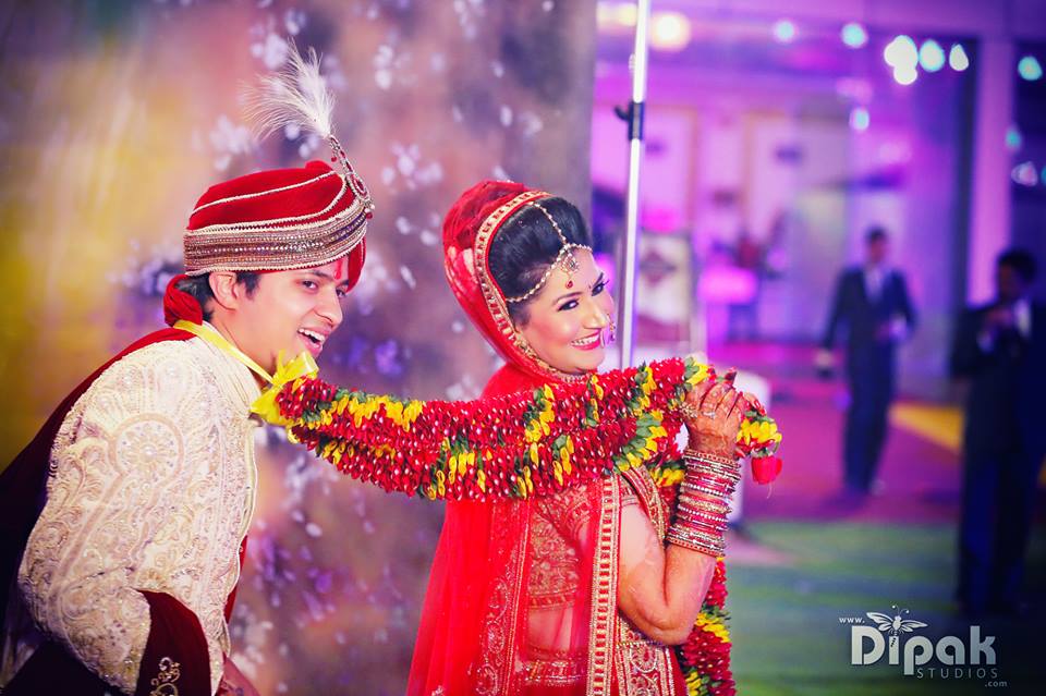 Portrait of an Indian wedding couple posing in front of camera for photo  album Stock Photo - Alamy